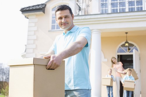 Movers carrying furniture through a Kingston Vale residential property